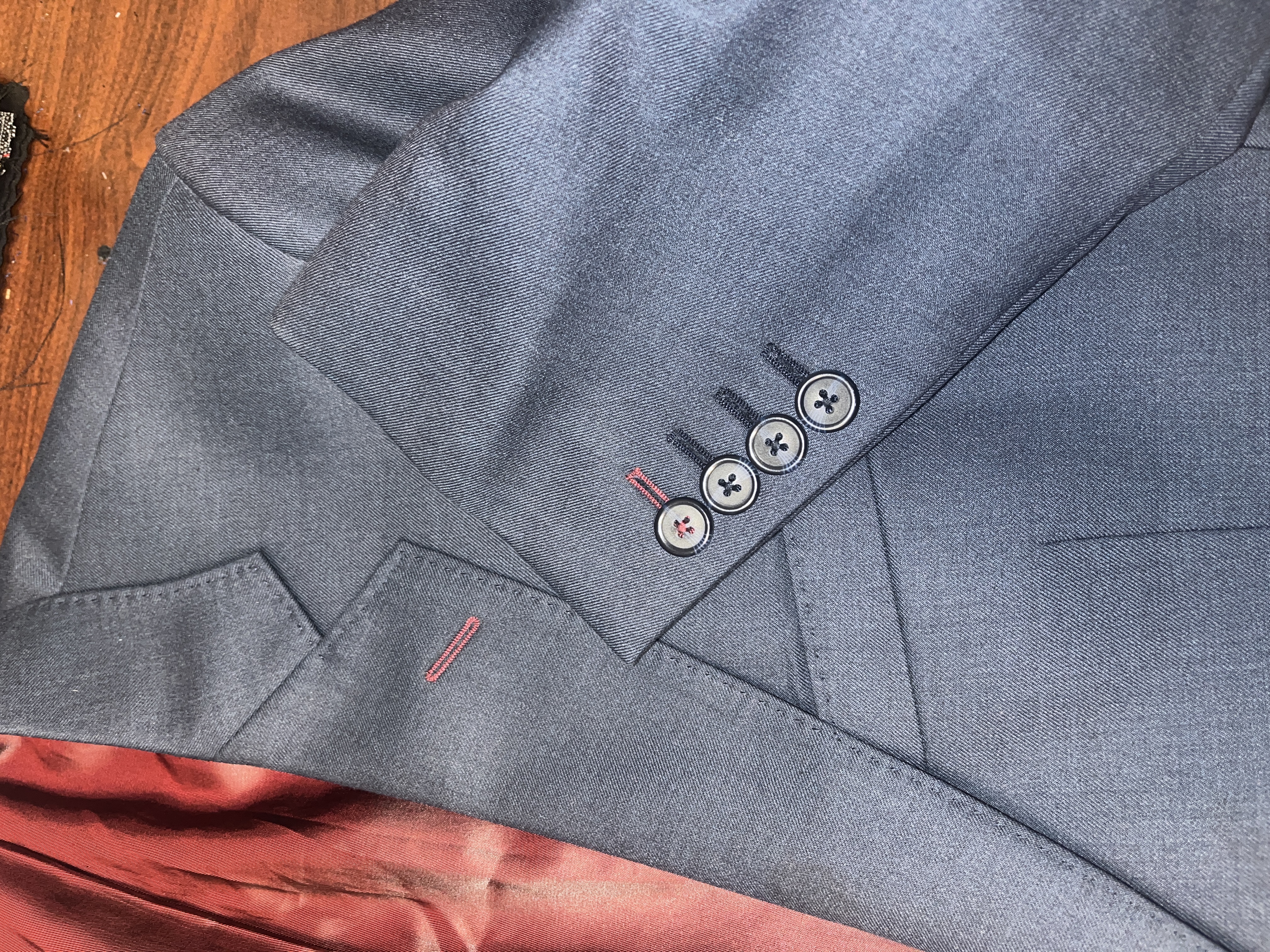 Distinctive suit jacket sleeve buttons featuring elegant contrast stitching, exemplifying the fine details by Essato Custom Clothing in Layton, Utah